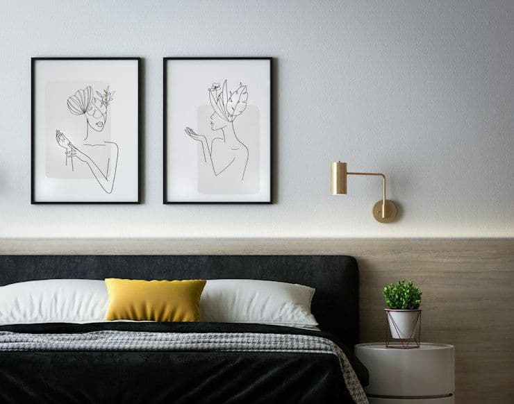 Bedroom with black headboard and minimal artwork