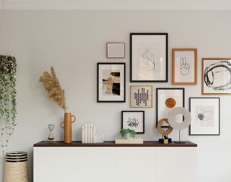 Gallery wall above a white sideboard with dried flowers