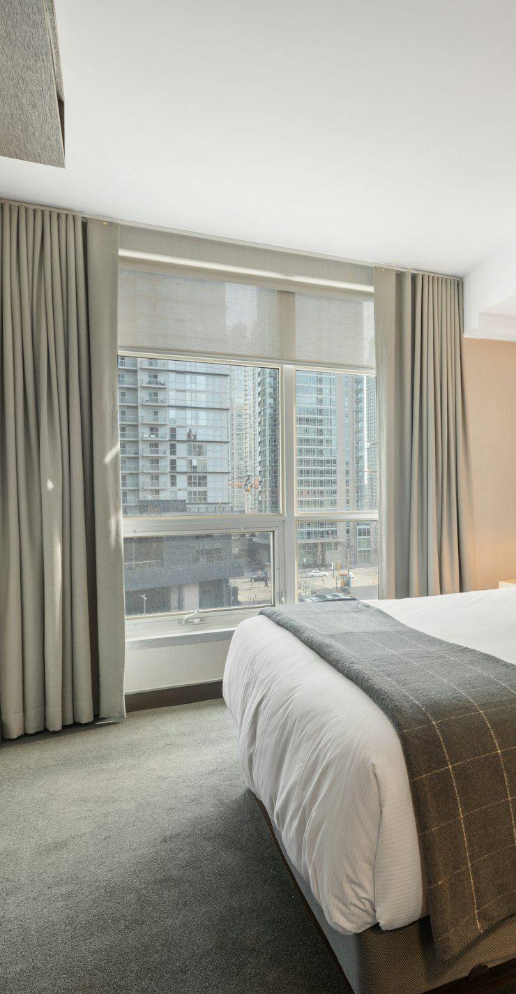 Bedroom with tall grey headboard and crisp linen