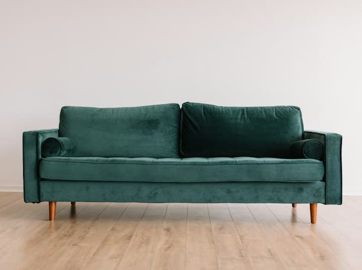 Emerald velvet sofa on oak flooring