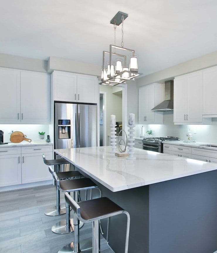 White kitchen with marble island and pendant lights